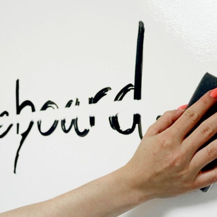 Roka ki briši z gobico napis na piši briši steni
